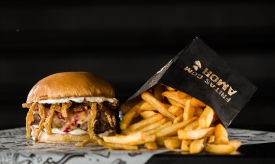 Imbiss & Kantinen Ein Cheeseburger mit einer Portion Pommes daneben